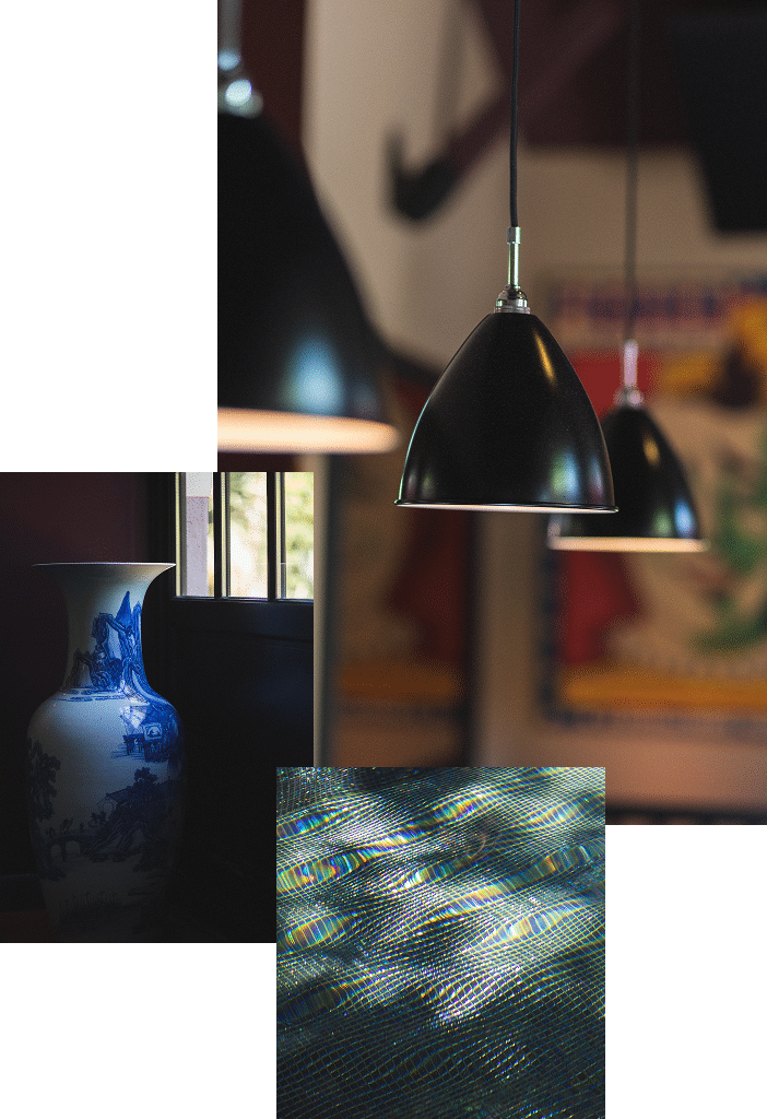 Vase bleu, suspensions noires et reflets irisés Composition sombre avec vase bleu et blanc près d'une fenêtre, des suspensions noires et un gros plan abstrait irisé de fines mailles.